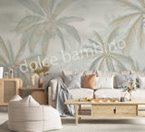 A section of wallpaper with a design of coconut trees and palm leaves in various shades of green, displayed in a room setting.