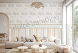 Modern living room with a light gray sofa, decorative pillows, and a elephant patterned wallpaper.