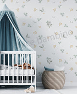 A wall adorned with a floral and leaf pattern wallpaper, featuring a white crib, a toy storage basket.