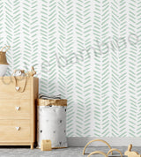 Children's room with a wallpaper of green leaf pattern,wooden furniture and toys.