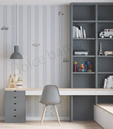 A modern children's bedroom light gray striped wallpaper. Decorative items like books, a toy ambulance, and a small Eiffel Tower model are displayed on the shelves.