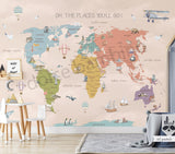 A pantone world map wall mural in a children's room, with the phrase 'OH, THE PLACES YOU'LL GO' at the top.