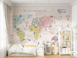 A pantone world map wall mural in a children's room, with the phrase 'OH, THE PLACES YOU'LL GO' at the top.