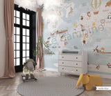 Children's room featuring a colorful world map wallpaper with illustrations of animals and vehicles. A wooden dresser and a canvas storage basket are visible in the room.
