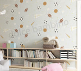 A room with walls covered in 'Spry Sports' wallpaper featuring a pattern of soccer balls, basketballs, footballs, tennis rackets, and cricket bats.
