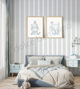 Kids bedroom with blue striped wallpaper, soft beige bedding, framed animal prints, and modern nursery furniture