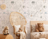A wallpaper featuring characters from Winnie the Pooh in a forest setting, with a teddy bear, a basket, and a cushion, in a room with a bed and a wicker chair.