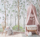 A nursery room with a crib, white furniture, and a wall mural featuring green birch trees.