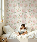 Child reading a book on a bed with floral wallpaper in background