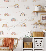 A room with walls covered in a wallpaper featuring Nordic pastel rainbows, fluffy clouds, and heart-shaped confetti.