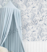 Delicate blue floral and butterfly wallpaper,paired with a pale blue draped canopy and white wall panelling.