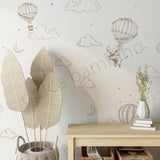 Wallpaper with hot air balloons and clouds, a wooden table, and decorative items.