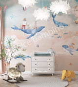 A whimsical underwater-themed wall mural featuring a humpback whale, lighthouses, fish, seahorses, jellyfish, and starfish, with hot air balloons in the sky, installed on a wall in a room with children's furniture.