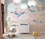 A Whale of a Time themed wall mural featuring a humpback whale, lighthouses, fish, seahorses, jellyfish, and starfish, with hot air balloons in the sky, installed on a wall in a room with children's furniture.
