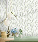 Wallpaper with a green and white pattern, featuring a lamp and decorative items on a table.