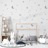 Children's room with a wallpaper of star and moon,wooden house bed, shelves, and toys. 
