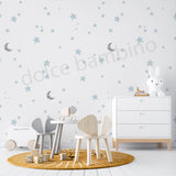 Children's room with star and moon wallpaper,wooden furniture, and toys.