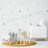 Children's playroom with furniture and decor, featuring moons and stars wallpaper on the wall.