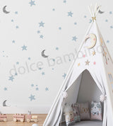 Children's teepee with decorative pillows and wallpaper of stars and moons in a child-friendly room.