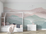 Children's room with a white crib, dresser, and pink elephant toy against a mountain-themed wall.