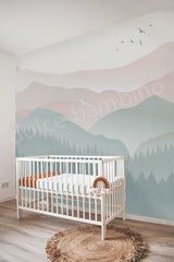 Children's room with a crib and mountain mural on the wall