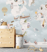 Children's room featuring a colorful world map wallpaper with illustrations of animals and vehicles. A wooden dresser and a canvas storage basket are visible in the room.