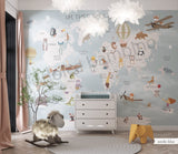 Children's room featuring a colorful world map wallpaper with illustrations of animals and vehicles. A wooden dresser and a canvas storage basket are visible in the room.