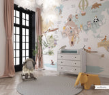Children's room featuring a colorful world map wallpaper with illustrations of animals and vehicles. A wooden dresser and a canvas storage basket are visible in the room.