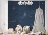 A space themed wallpaper featuring a deep blue celestial scene with illustrations of planets, a spaceship, and stars. 
