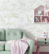 Children's room with white wall with green animal prints,mint green sofa, pink side table, and dollhouse.