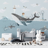 Children's room with whale wall decal, toys, and a bed.