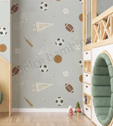 A room with walls covered in 'Spry Sports' wallpaper featuring a pattern of soccer balls, basketballs, footballs, tennis rackets, and cricket bats.