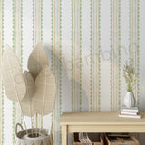  wall with striped pattern wallpaper, table with books and vase, and plant.