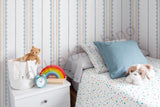 Children's bedroom with striped pattern wallpaper, bed, teddy bear, and colorful decor.