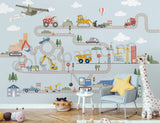 Children's room with a wall mural of a road with vehicles and a chair with a yellow pillow.