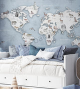 A wall mural featuring a watercolor animal world map with various continents, oceans, and wildlife illustrations, displayed in a room setting with furniture.