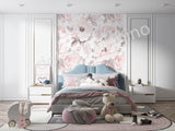 A section of pink wallpaper with a floral pattern, showcasing magnolia flowers, applied on a wall in a room with furniture.